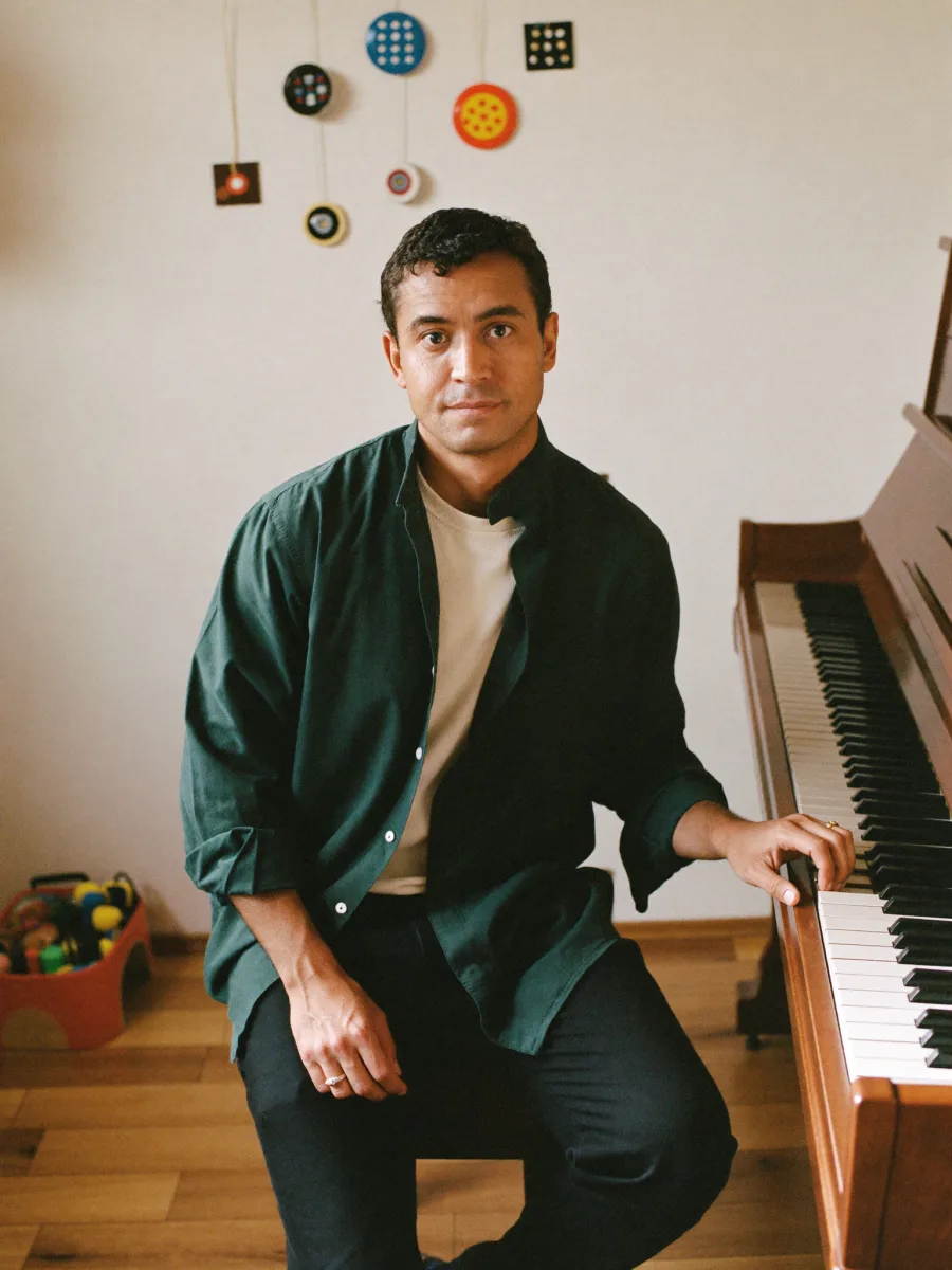 Retrato ficticio generado de un profesor junto a un piano en una sala de música.